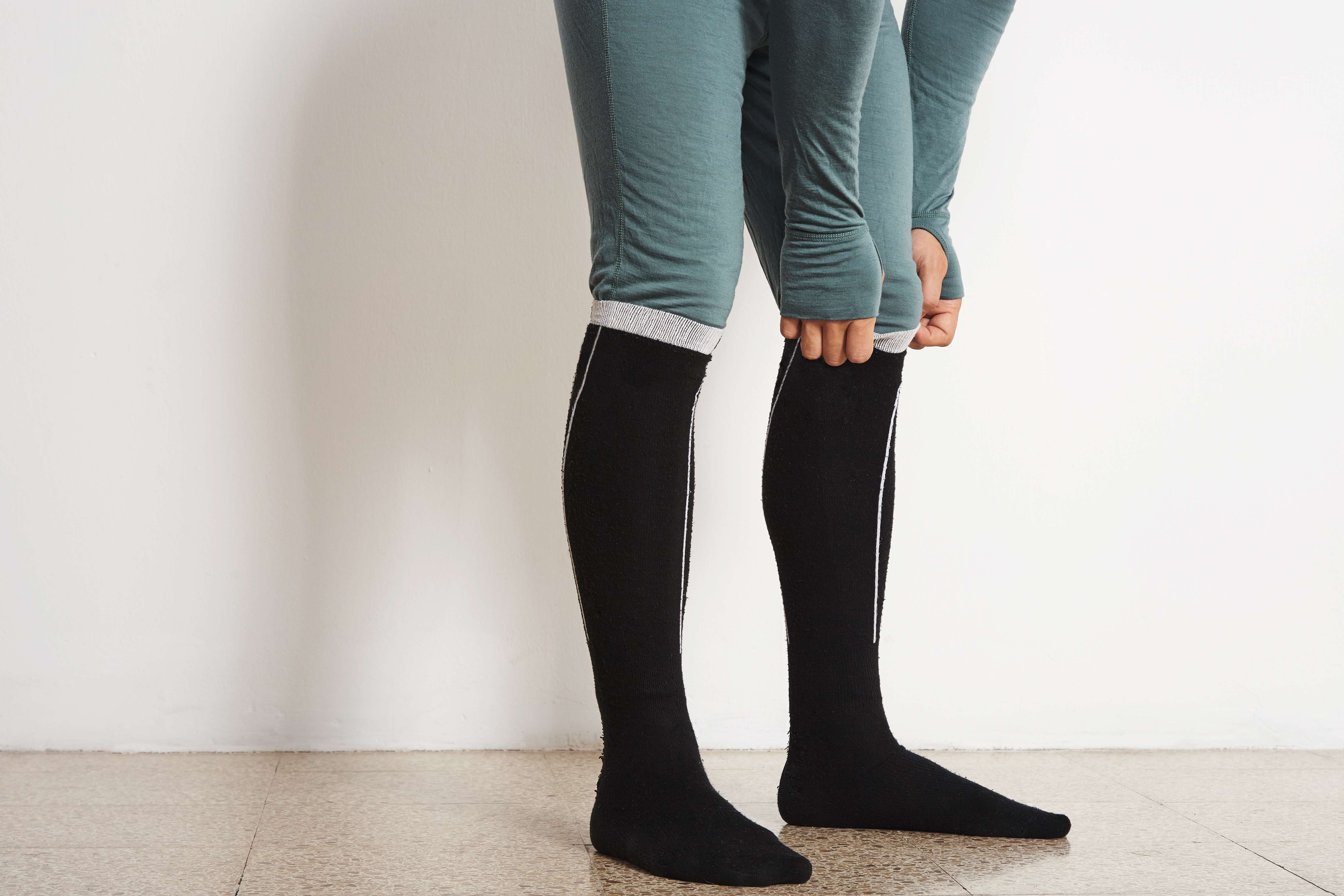 Male athlete legs wearing long thermal compression socks
